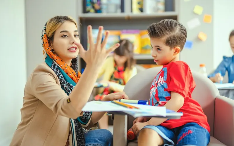 Fonoaudióloga conversando y jugando con un niño durante una sesión