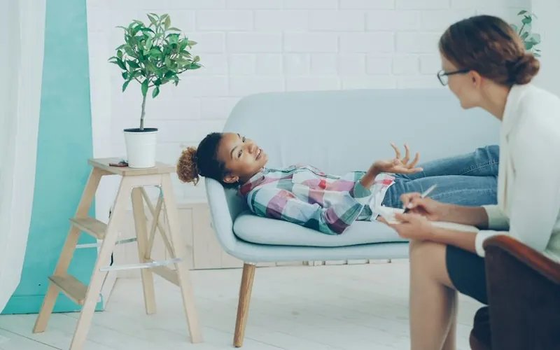 Niña conversando con una psicóloga infantil en un ambiente cálido